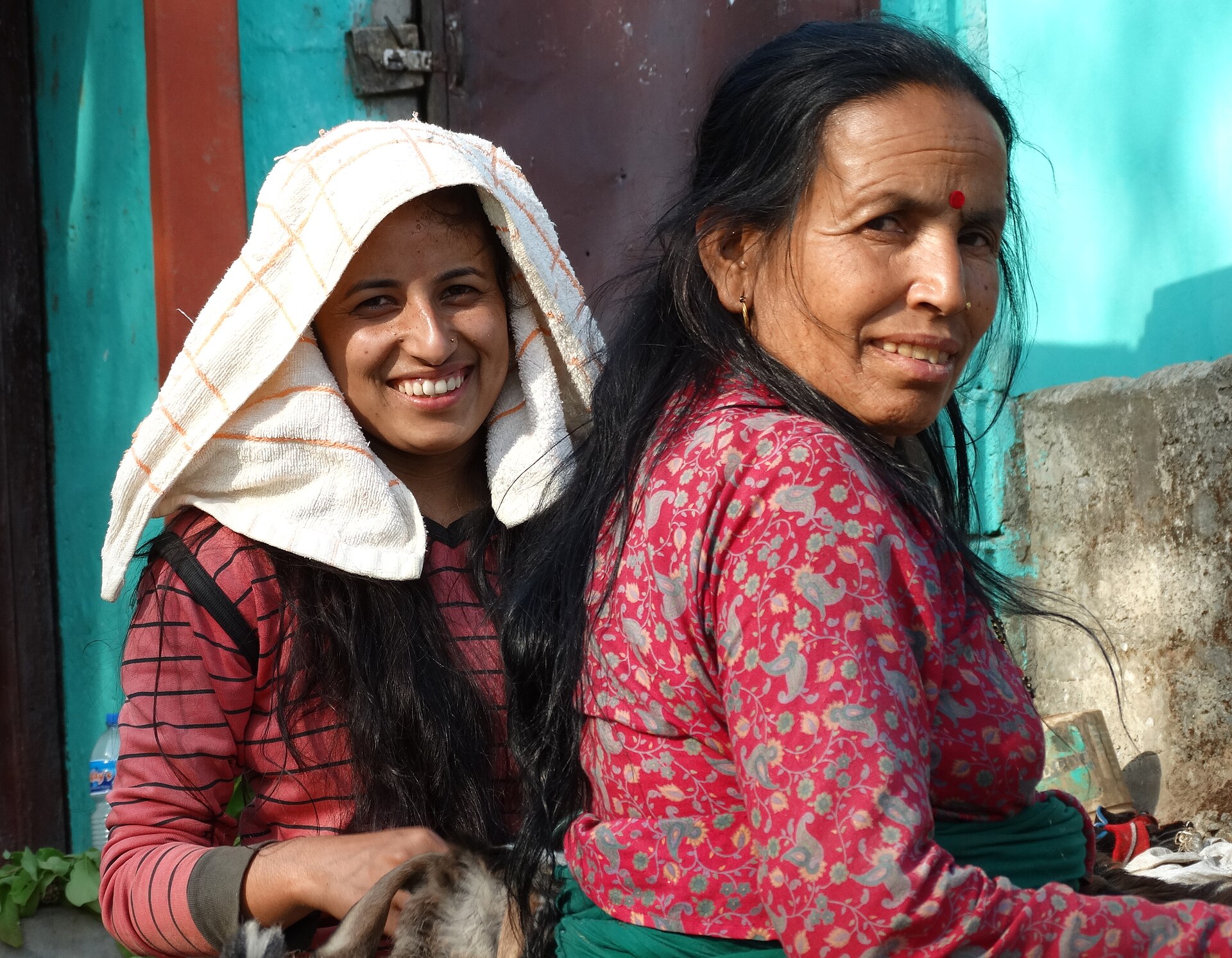 Two women from a local community smiling together