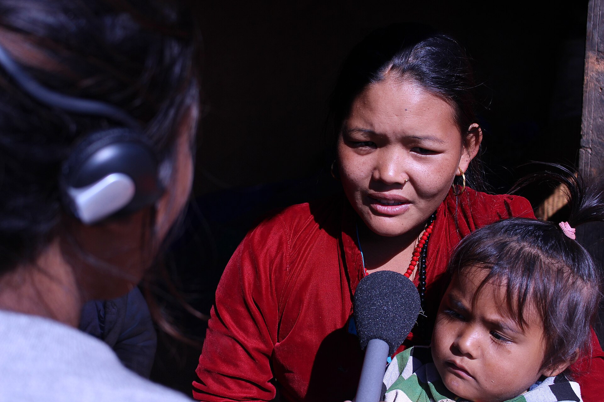 A reporter interviewing a woman with a microphone