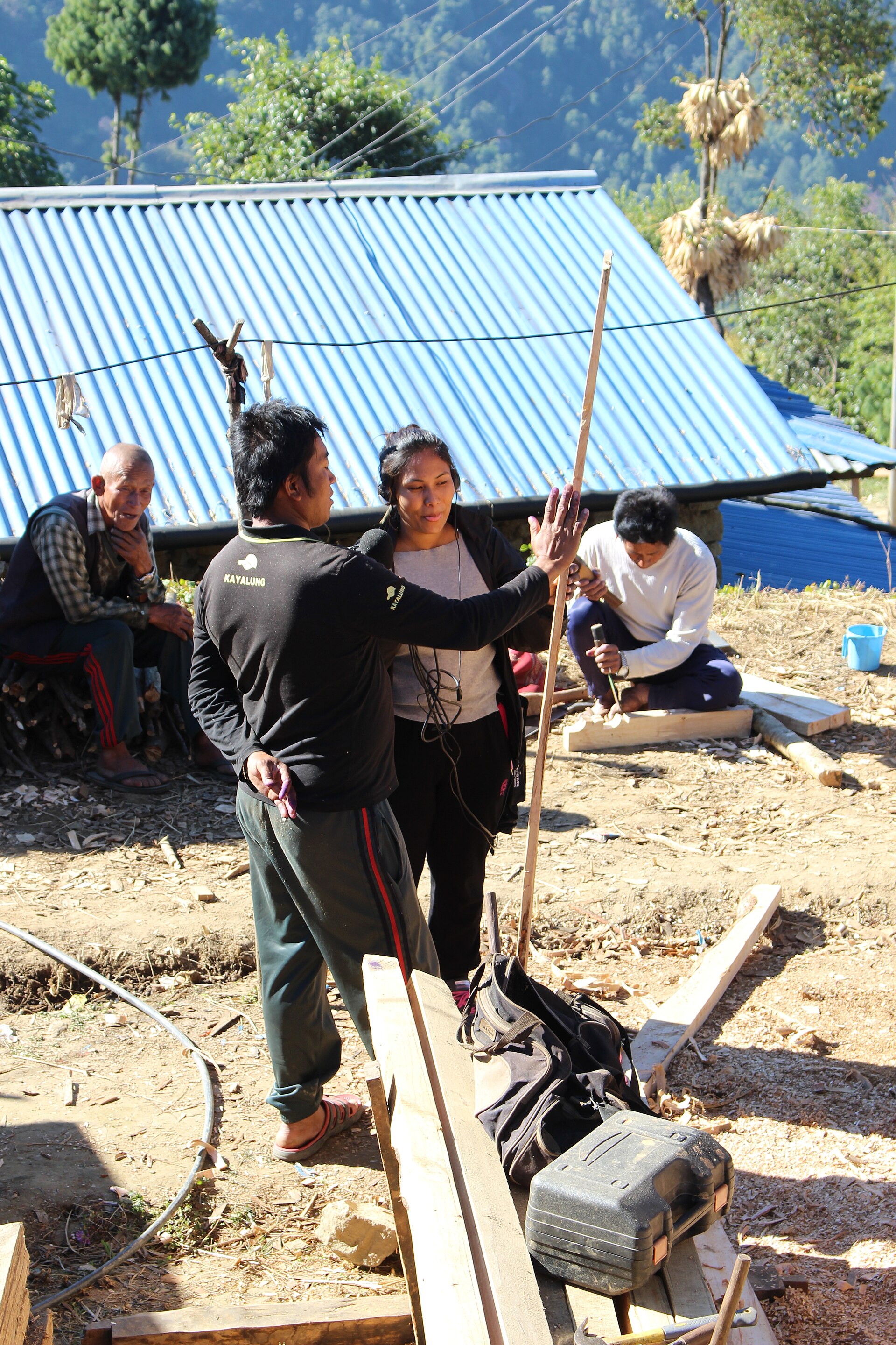 Researchers taking measurements during fieldwork in a village