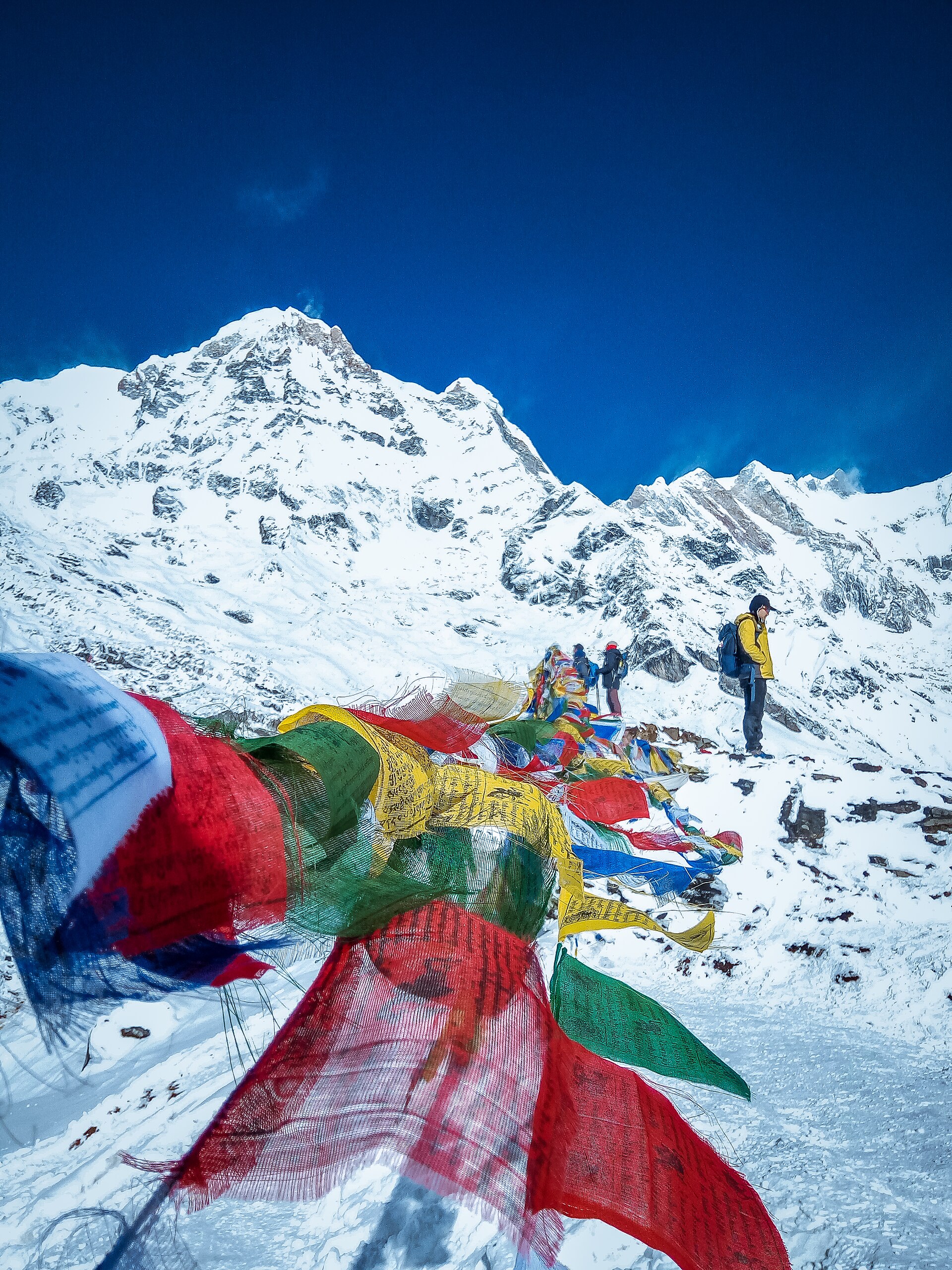 Trekkers among prayer flags below the Annapurna peaks