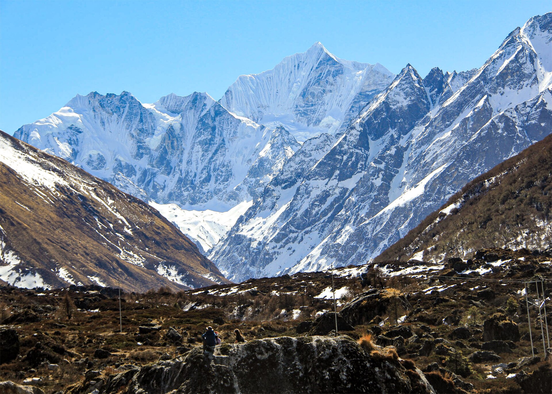 A Himalayan valley trail below snow-covered peaks