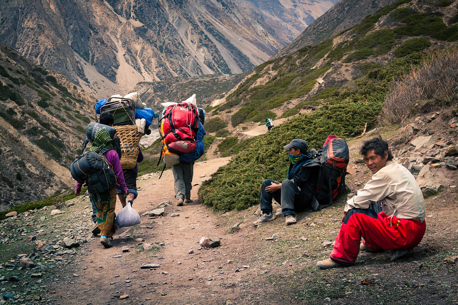 Porters and trekkers resting along a mountain trail
