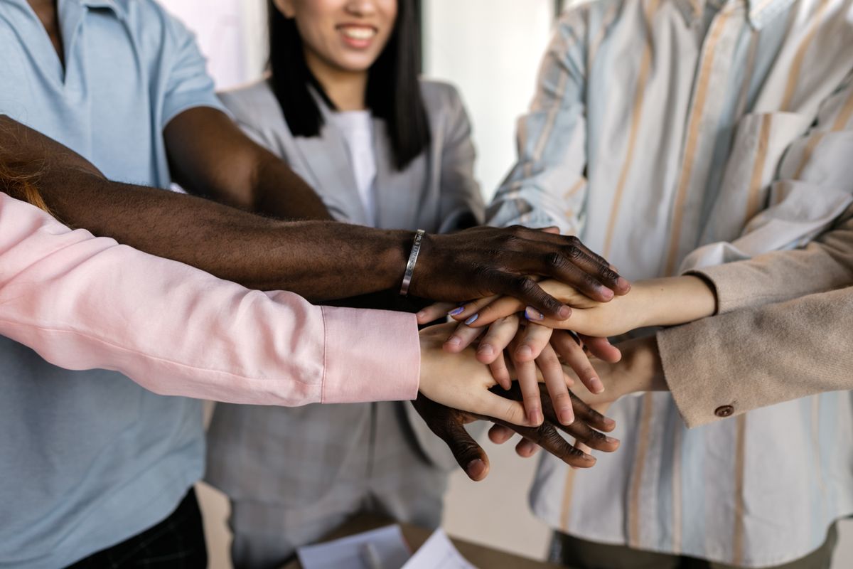 Volunteers joining their hands together as a team